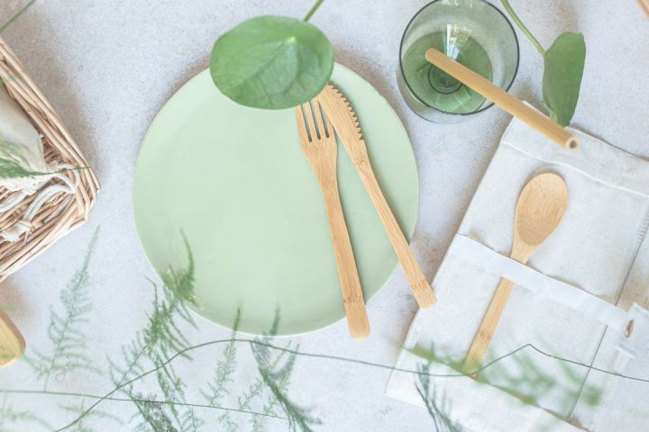 Eco-friendly Product - a green plate with wooden utensils on it