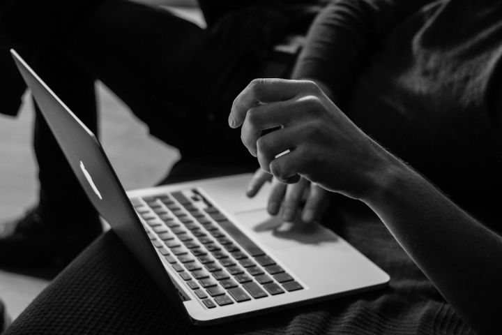 Online - grayscale photo of person using MacBook