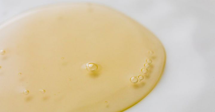 Beauty Essentials - Transparent yellowish liquid on white surface